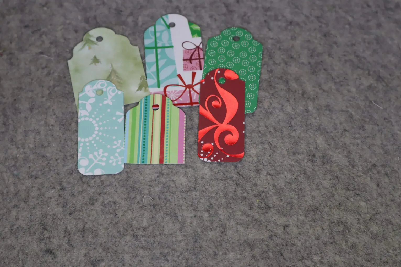 Colorful decorative gift tags arranged on gray surface.