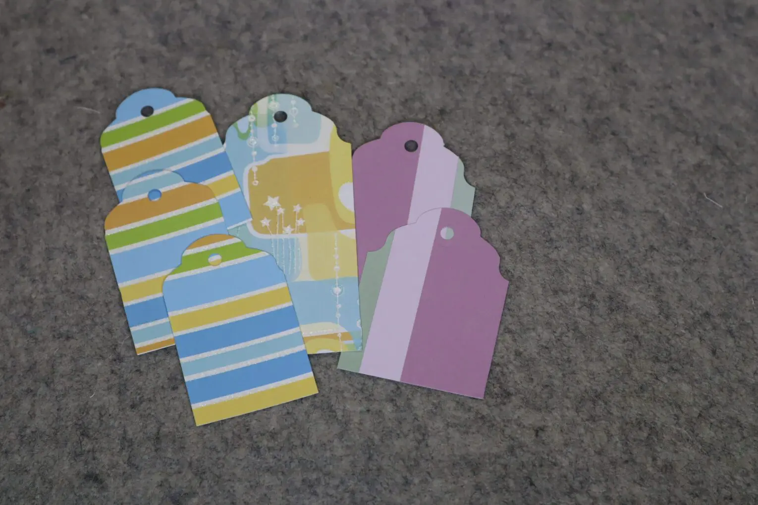 Colorful gift tags arranged on a gray surface.