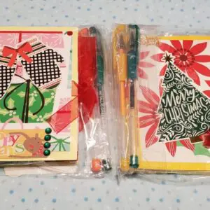 Colorful holiday cards packaged with decorative ribbons.