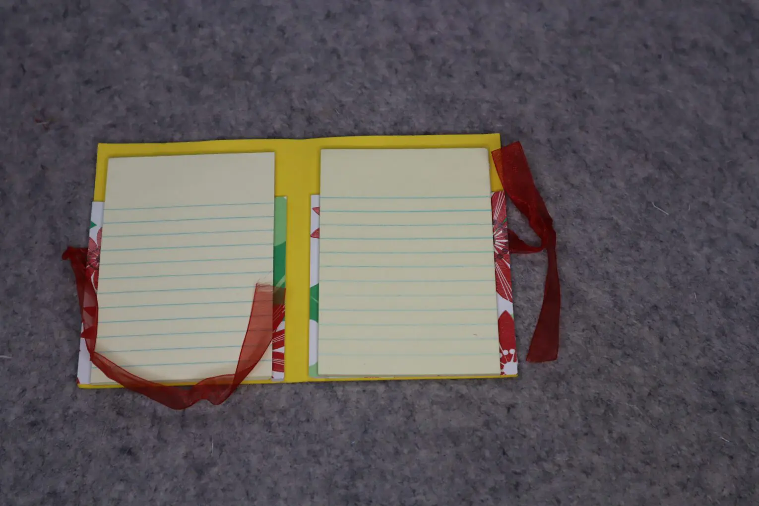 Colorful notepad with lined pages and ribbon.