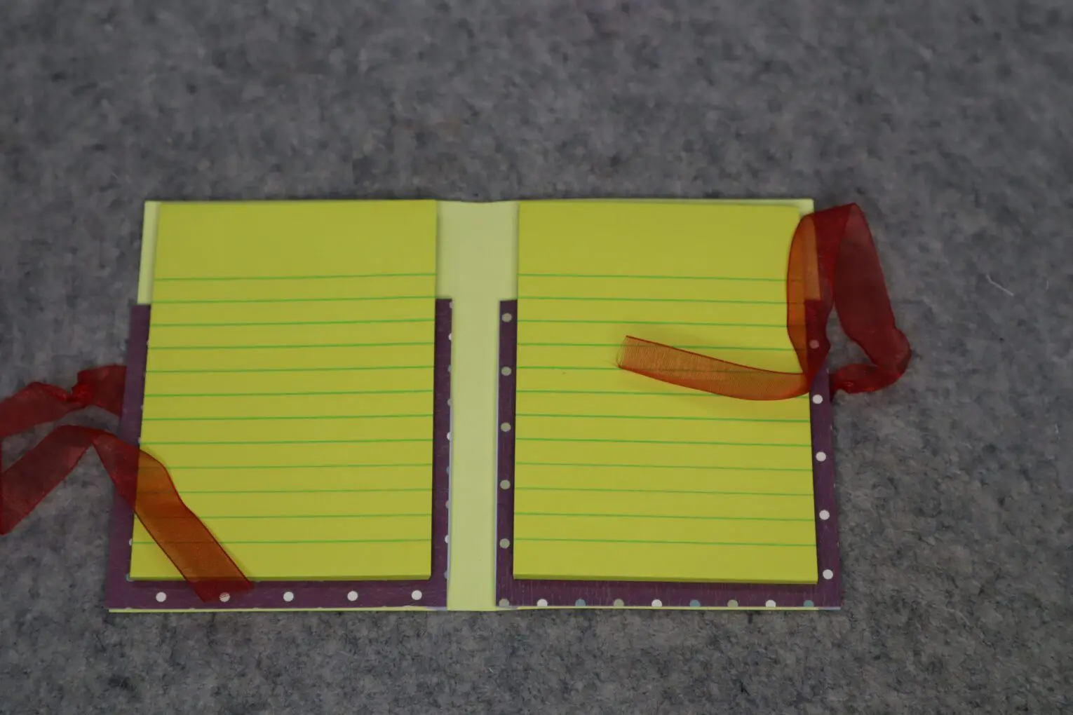 Yellow notepad with ribbon accents displayed open.