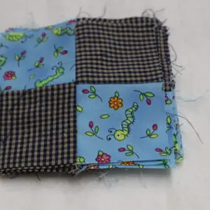 Patchwork fabric square with colorful and checkered patterns.