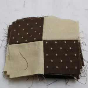 A small fabric patch with a brown and beige checkerboard pattern.