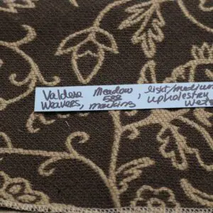 A carpet with a white strip containing handwritten names.