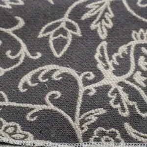 Close-up of a gray fabric with white floral embroidery.