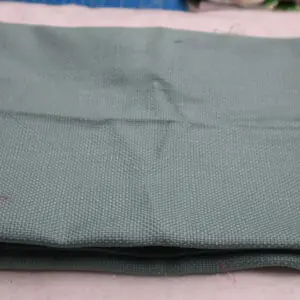 Folded light green fabric piece on a flat surface.