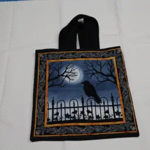Black tote bag with a spooky Halloween design featuring a raven and a full moon.