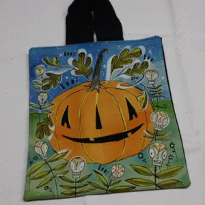 A colorful bag with a smiling pumpkin design and floral background.