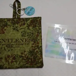 Green fabric sachet with a label and a small packet beside it.