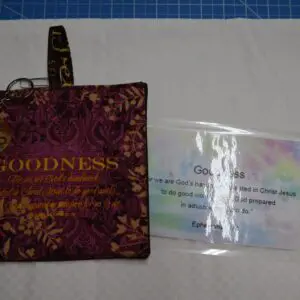 A fabric pouch and a laminated card on a white surface.