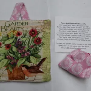 A gardening book and a pink patterned sachet on a white surface.