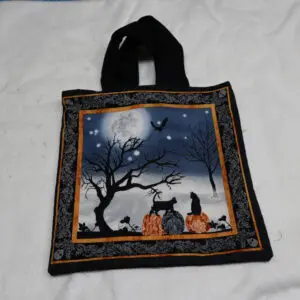 Black fabric bag with Halloween-themed artwork of a moonlit night and two children.