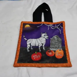 Halloween-themed tote bag with a zebra, tombstone, and pumpkins.