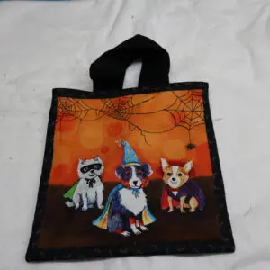 Halloween tote bag with three cartoon dogs in costumes.