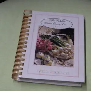 A spiral-bound cookbook titled "The Italian Kitchen" with a cover photo of fresh vegetables.
