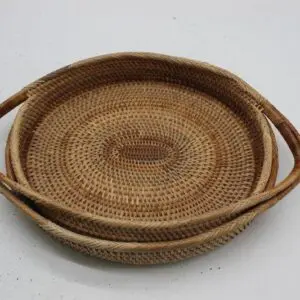 Round woven basket tray with handles on a white background.