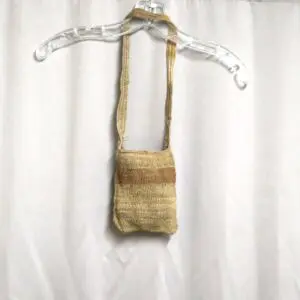 Handwoven small shoulder bag hanging on a clear plastic hanger.