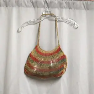Handwoven multicolored bag hanging on a clear hanger.