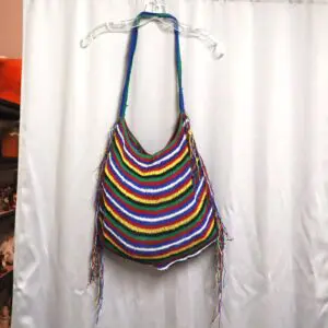 Colorful striped shoulder bag with fringe details.