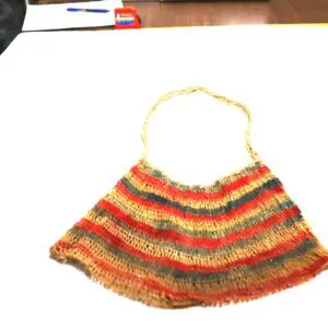 Handmade crochet bag with multicolored stripes and a braided handle.