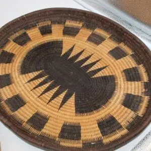 Handwoven basket with geometric patterns in natural and dark tones.