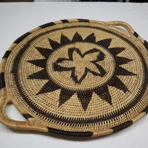 Woven basket tray with sun and star motifs and handles.