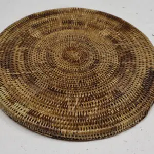 Round woven basket lid with intricate patterns.