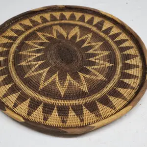 Handwoven circular basket with intricate geometric patterns.