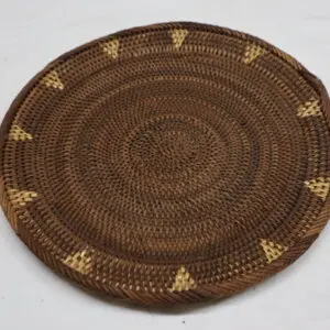 Handwoven round basket with decorative patterns.