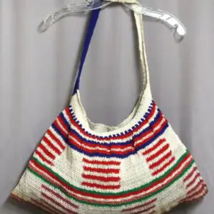 A colorful handmade crochet shoulder bag with blue, red, and green patterns.