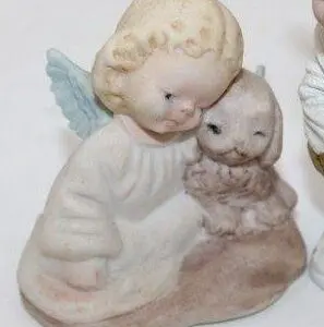 A ceramic figurine of an angel hugging a cat.