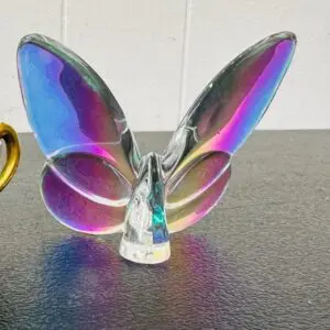 Iridescent glass butterfly figurine on a table.