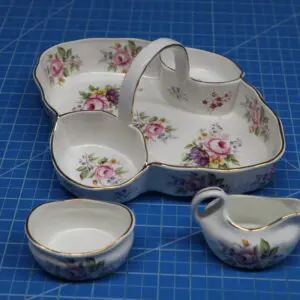 Floral ceramic condiment set with divided tray, bowl, and spoon rest.