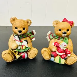 Two teddy bear figurines holding musical instruments, one with a bow.