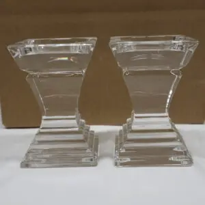 Pair of clear glass candle holders with tiered bases and flared tops.