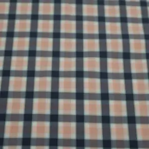 Close-up of a plaid fabric with navy, brown, and white colors.