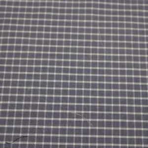 Close-up of a dark fabric with a white grid pattern.