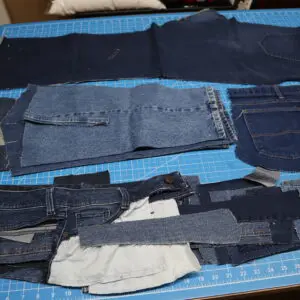 Pieces of denim fabric laid out on a table for sewing.