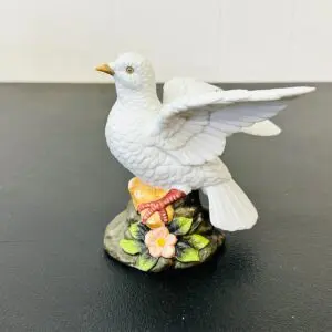 Porcelain dove figurine perched on a floral base.