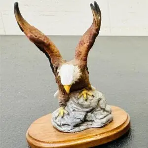 A detailed eagle sculpture on a wooden base.