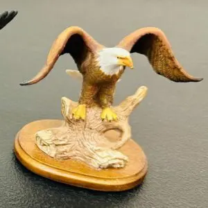 A detailed eagle figurine perched on a wooden base.