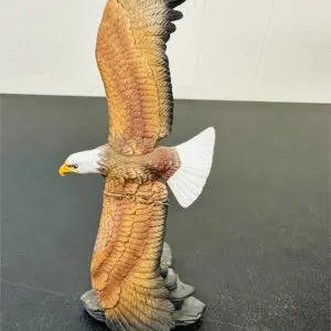 A detailed eagle sculpture with spread wings on a rock base.