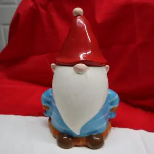 A small gnome figurine with a red hat and blue outfit.