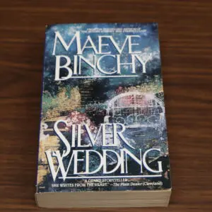 Paperback copy of Maeve Binchy's 'Silver Wedding' on a wooden surface.