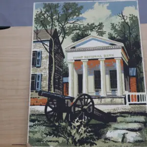 Historic building with columns, a cannon, and large tree in front.