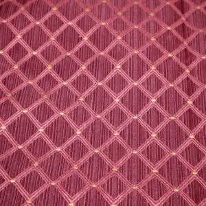 Close-up of a red fabric with a diamond lattice pattern.