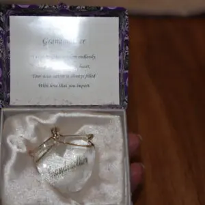 Heart-shaped glass pendant with a silver key inside a velvet-lined box.