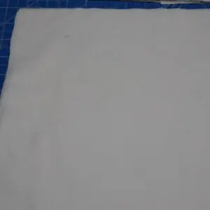 Plain white fabric laid flat on a blue surface.