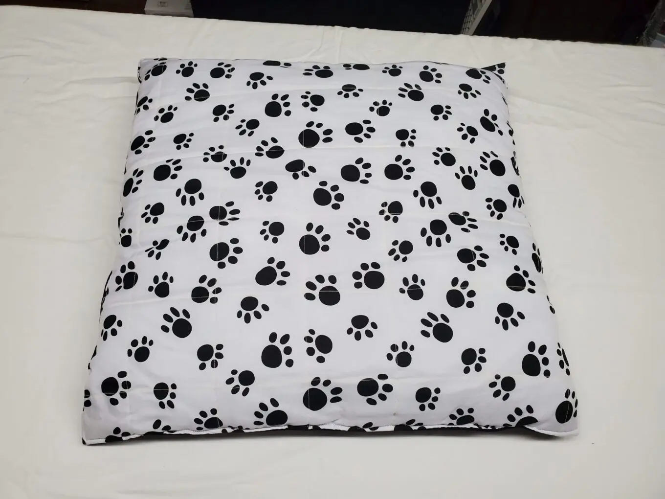 Pet themed cushion with monochrome paw pattern