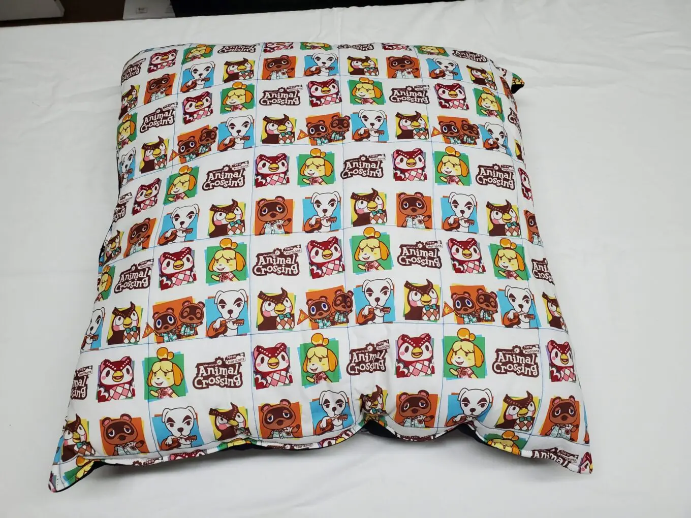 Animal Crossing patterned pillow on white bed